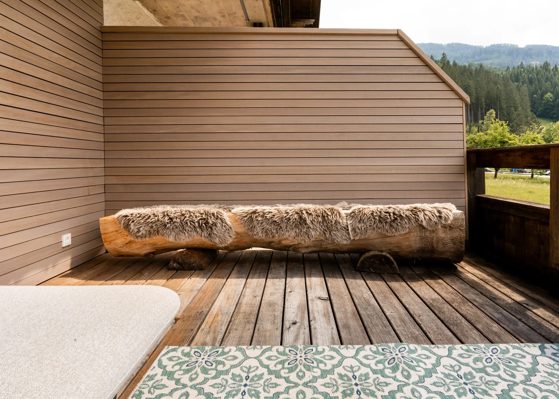 Deck with log and sheepskin bench at Hinterstoder ski residence
