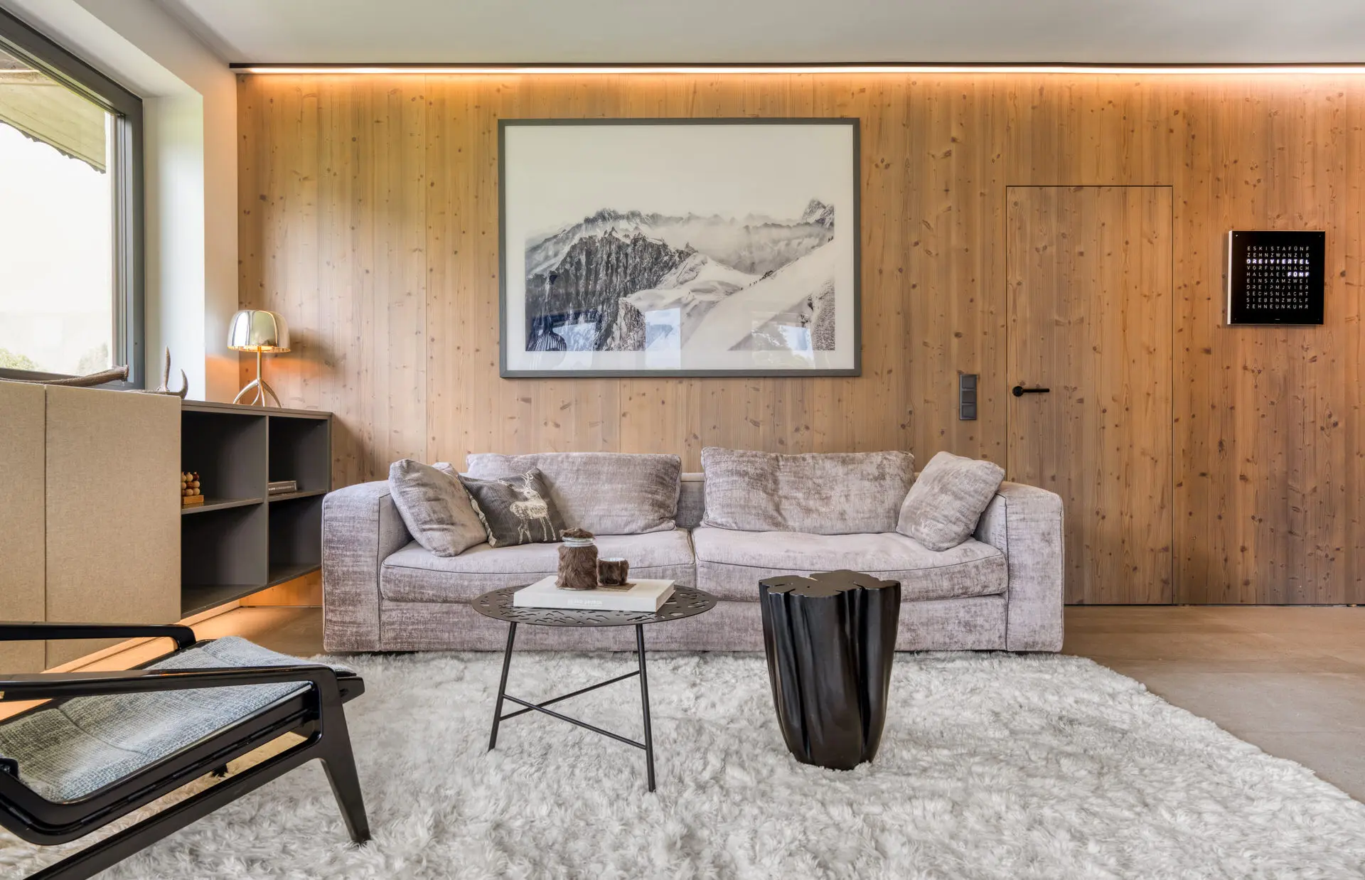 Living room with velvet sofa and art in Hinterstoder alpine residence