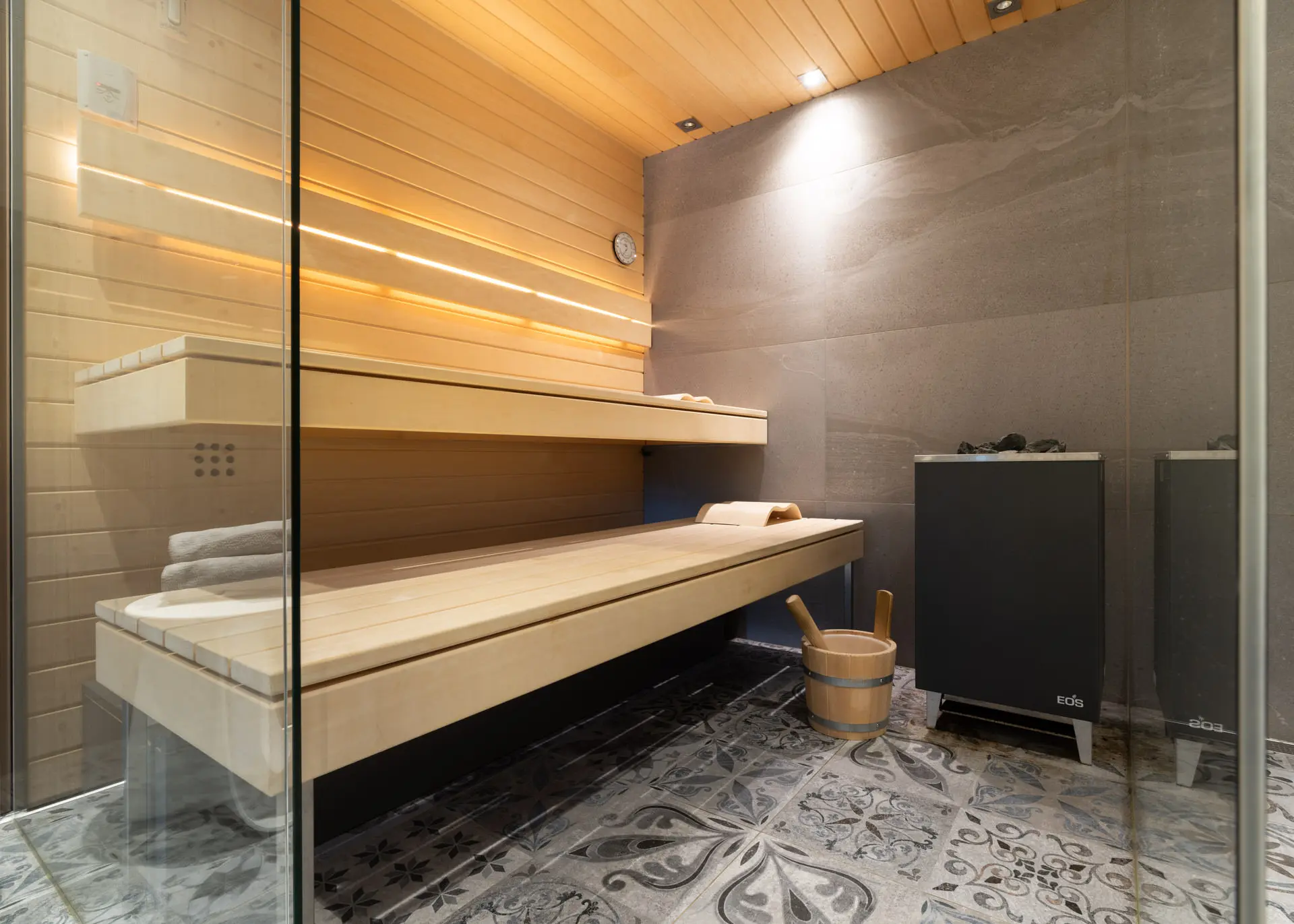 Sauna with glass partition and wood bench in Hinterstoder ski residence