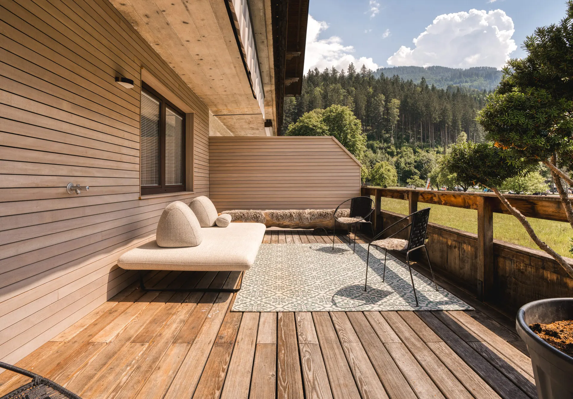 Timber deck terrace overlooking forest at Hinterstoder alpine residence