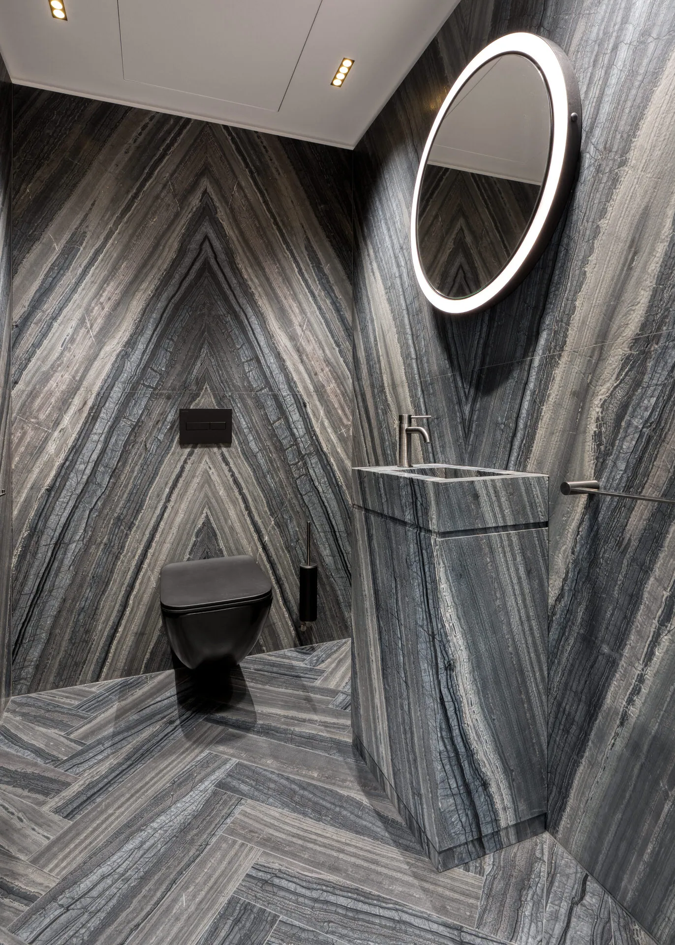 Powder room with chevron marble tiling in Vienna luxury penthouse
