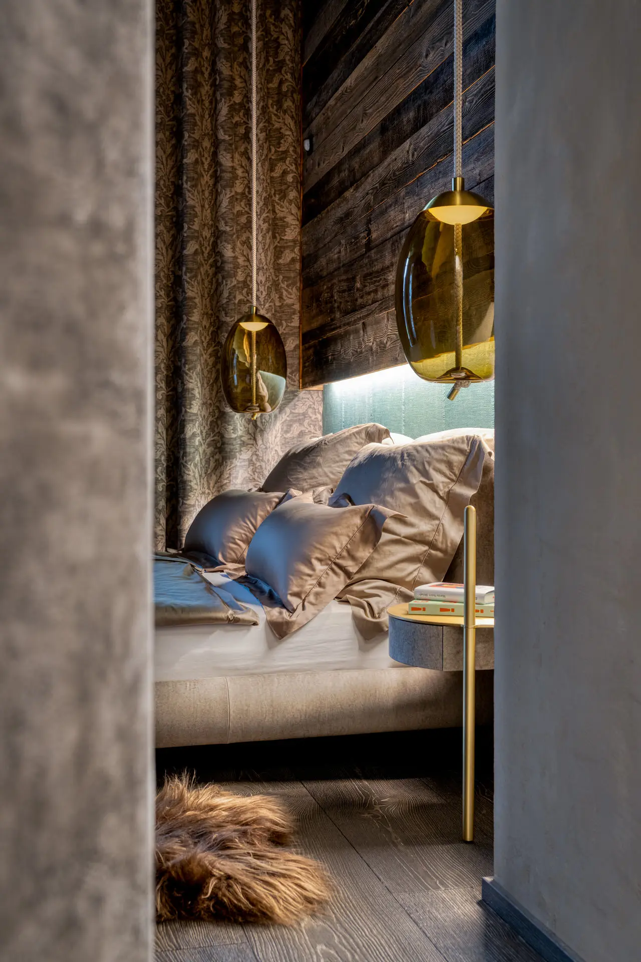 Baxter Stone bed with reclaimed timber wall in Kitzbuehel chalet bedroom