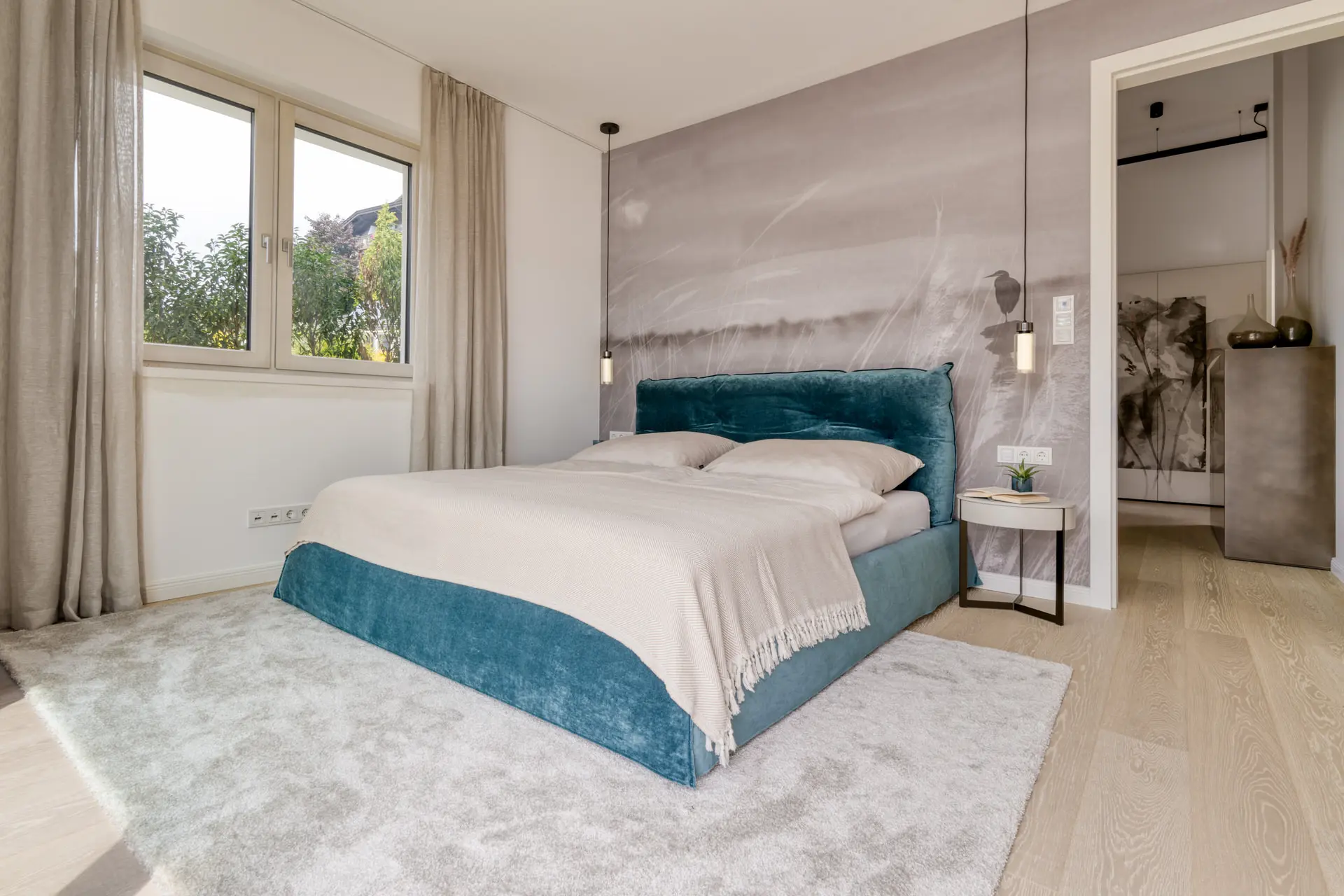 Bedroom with teal velvet bed in Millstätter See lakeview apartment