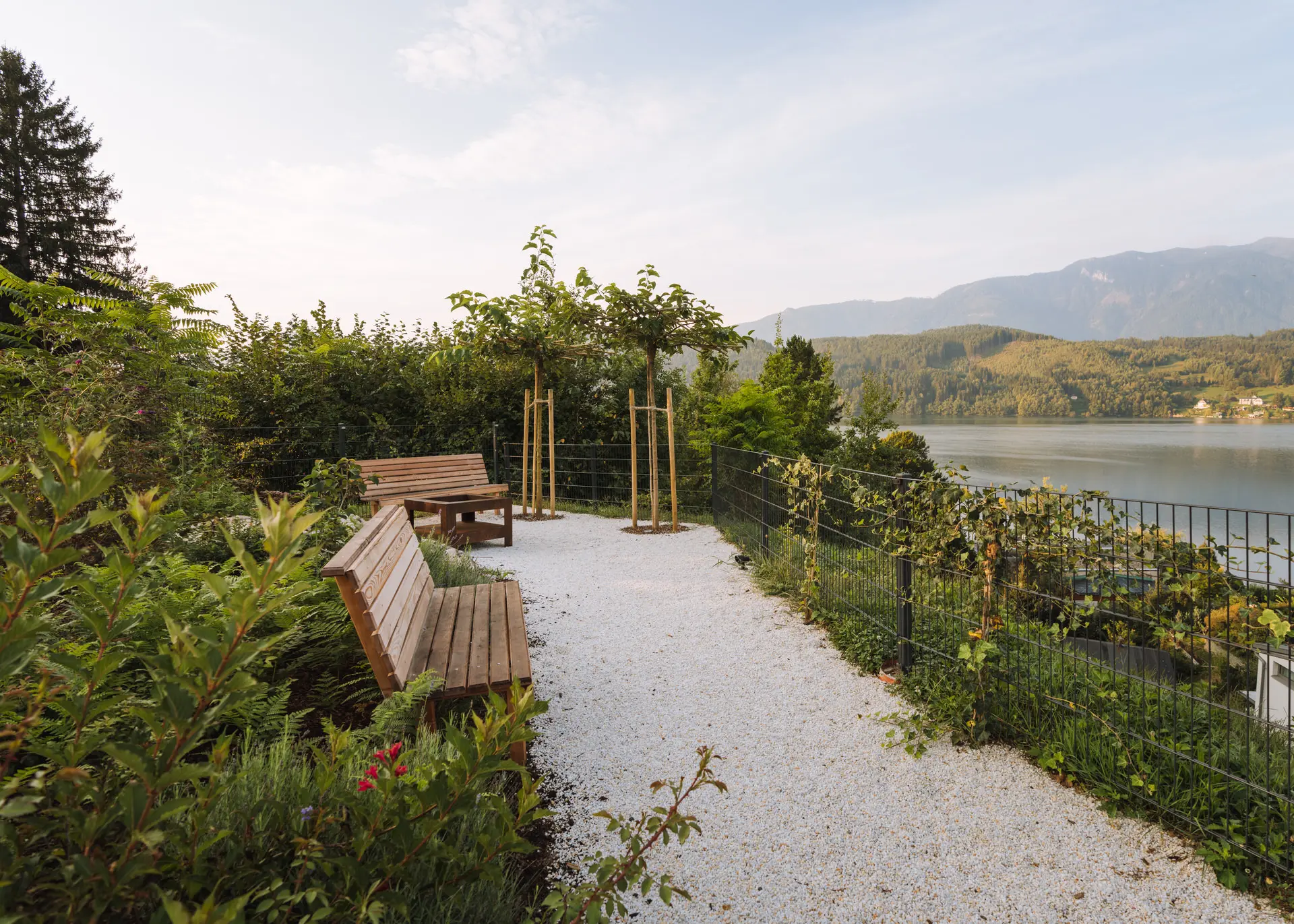 Garden bench along gravel path at Millstätter See luxury apartment
