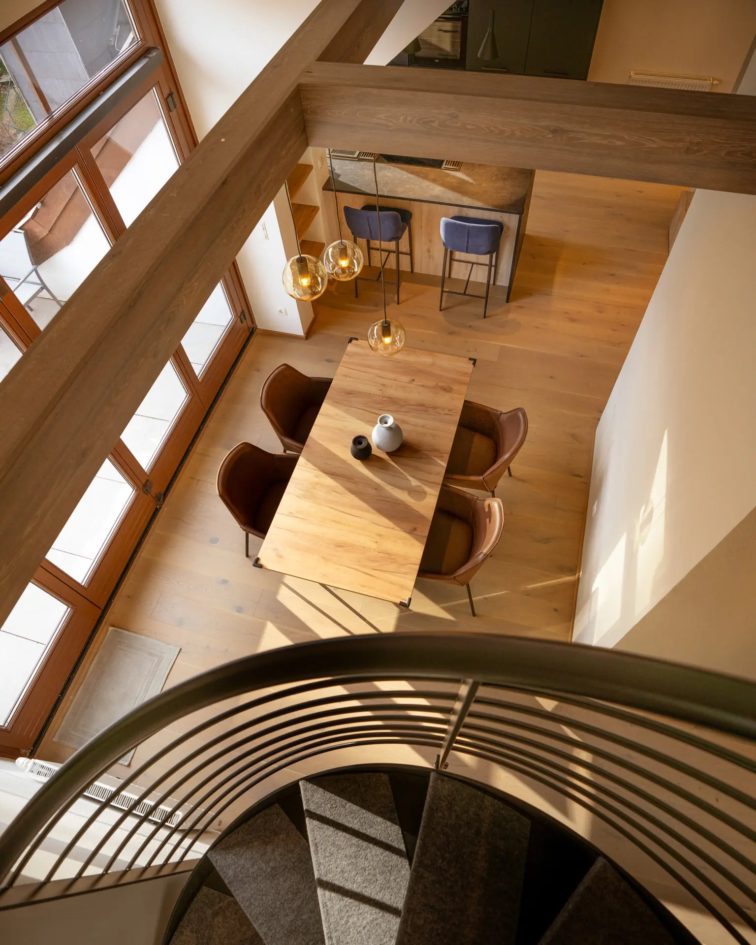 Overhead view of spiral staircase and dining area in Linz apartment