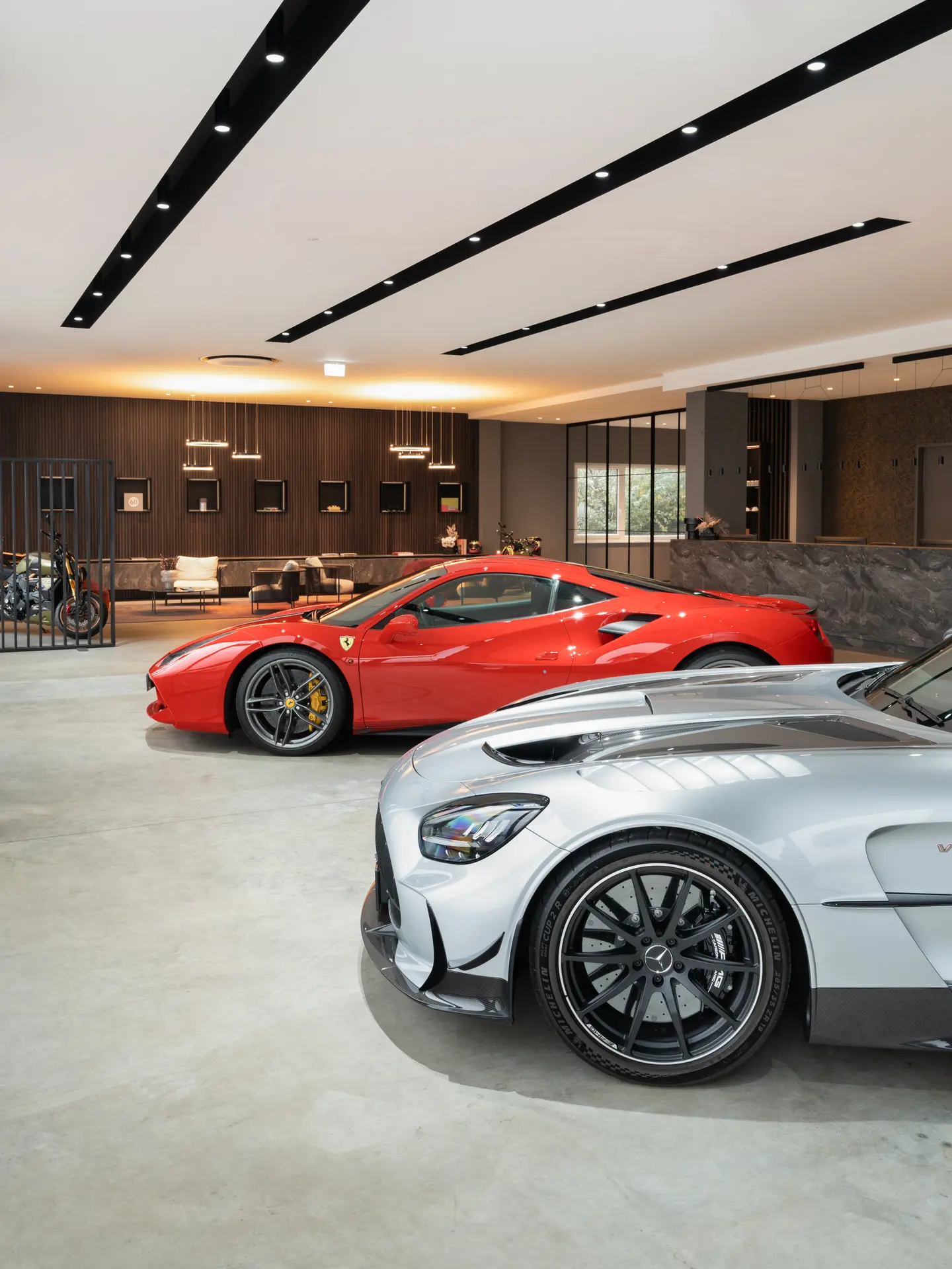 Low angle view of AMG GT and Ferrari in the luxury showroom